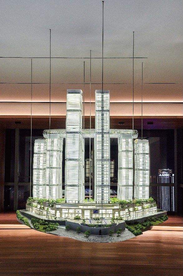 Suspended tower model above a green base in a lit lobby