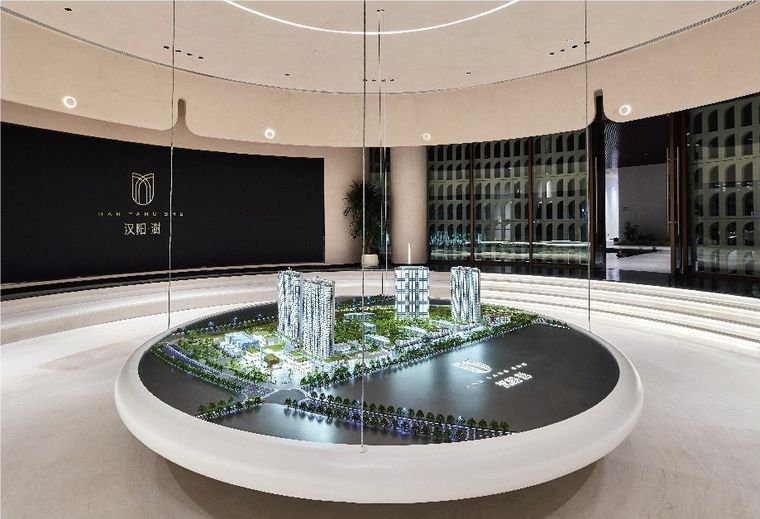 Project model on a circular white base in a curved showroom