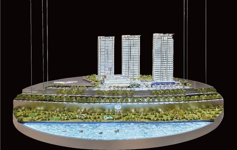 Suspended tower model above a circular base with a lit water feature