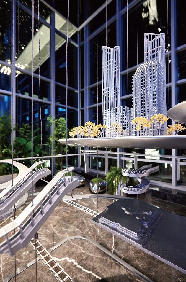 Close view of a suspended crystal tower model above a metal base