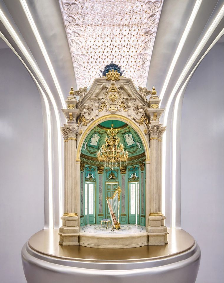 Exhibition hall with master plan models on tiered oval platforms