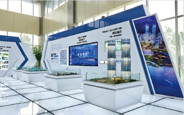 Exhibition pavilion with curved ceilings and a central model on a lit base