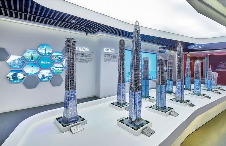 Exhibition hall with a curved screen and a regional model before it