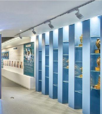 Exhibition hall with wall exhibits and a model on a central platform