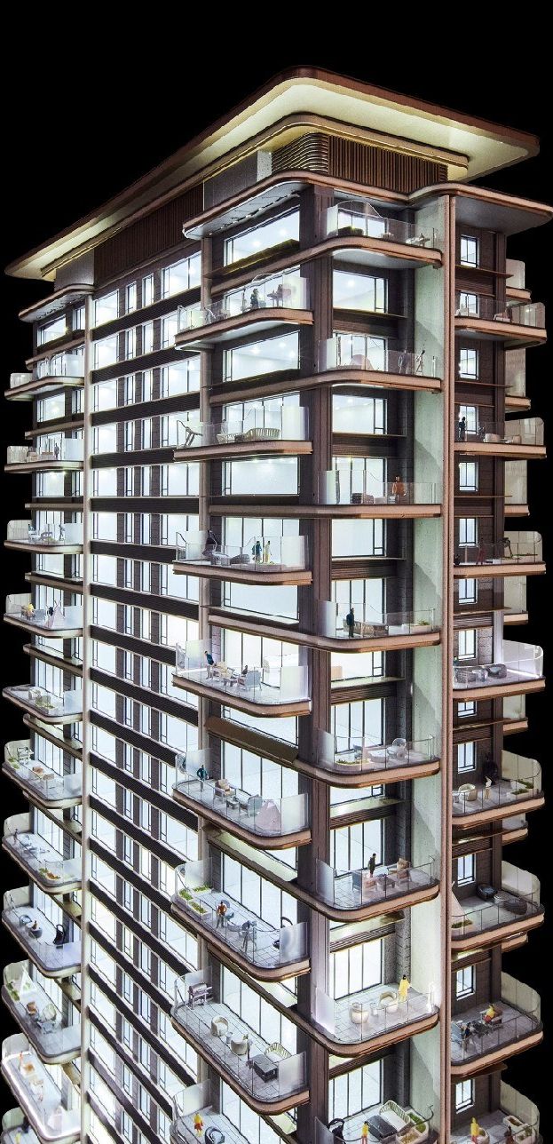 Model of a residential tower with planted balconies lit at night against black