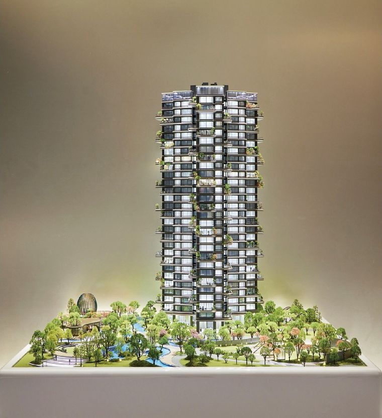 Model of a residential tower amid complete site landscaping with gardens and pools