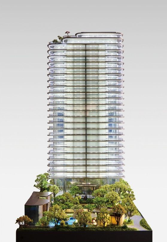 Model of a residential tower with circular roofs and a garden at its base