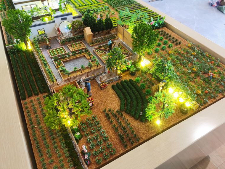 Raised planting beds lit at night inside a display case