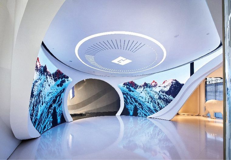 Immersive exhibition hall with mountain screens and a lit tunnel