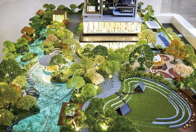 Model of a park with a stream and a grass terrace before a glazed building