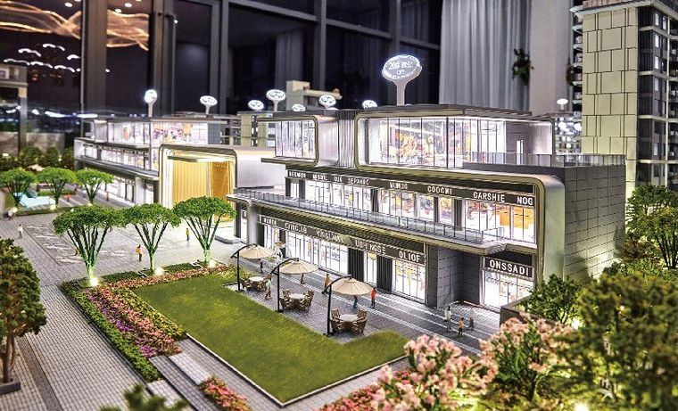 Model of a retail frontage with canopies and trees, lit at night