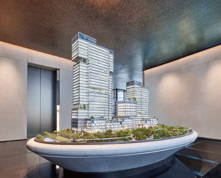 Office tower model with its retail podium on an oval base in a lift lobby