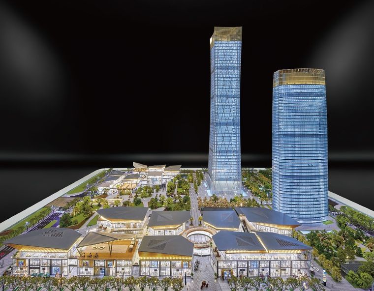 Model of a business complex and its urban setting on a long display table