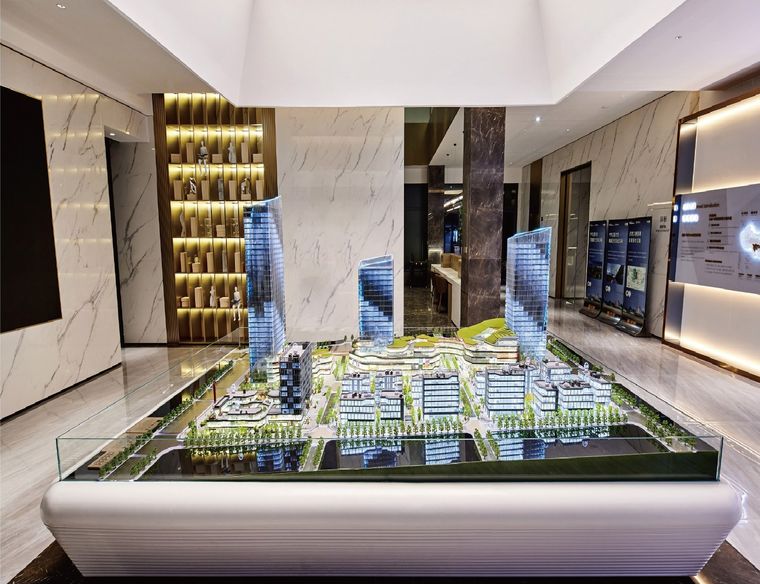 Model of a commercial and administrative complex lit from within on a black ground