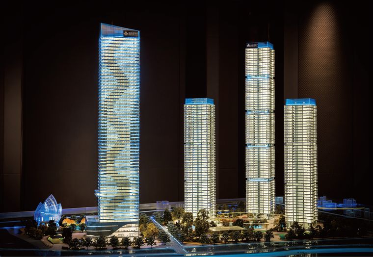 Model of a curved-roof shopping centre with the towers behind it
