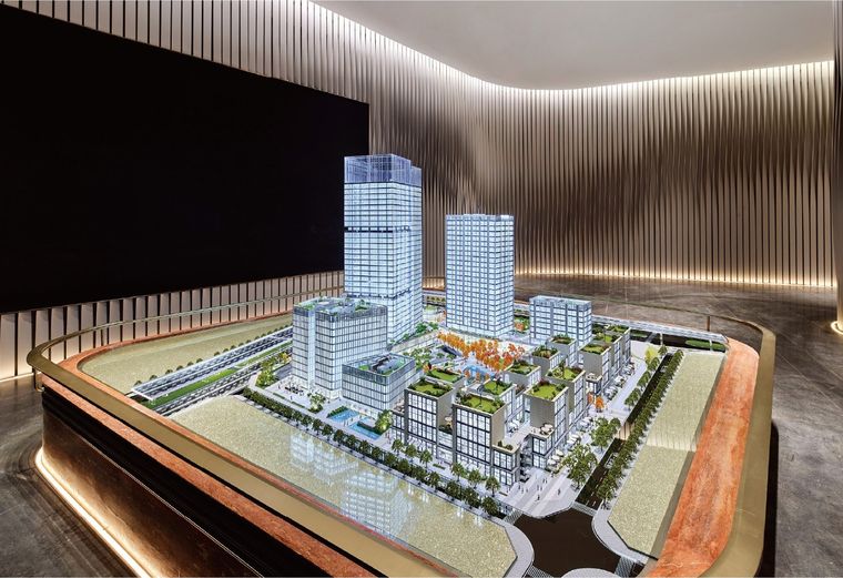Office tower model inside a glass vitrine in a marble lobby