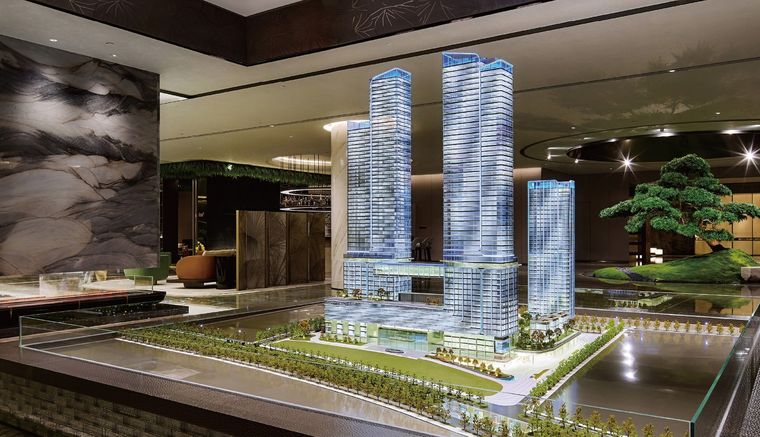 Model of a tower complex on a long black base in an exhibition hall