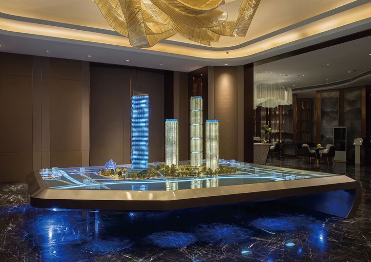 Tower models in a hotel lobby under golden lighting
