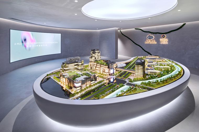 Retail district model on an oval base in front of a curved screen