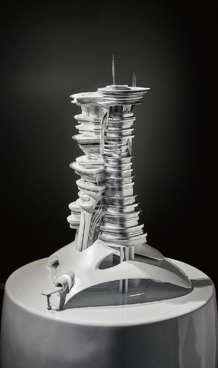 Model of a sculpted silver tower in interlocking layers on a circular base