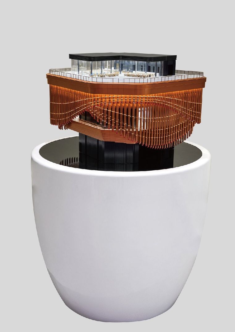 Model of a cultural centre with interlocking roofs and white trees on a display base