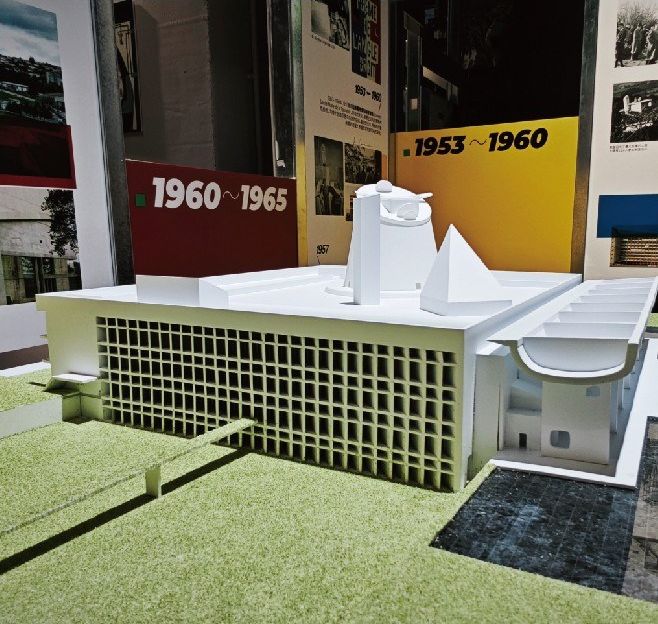 Model of a public building with a glazed facade and an extended roof
