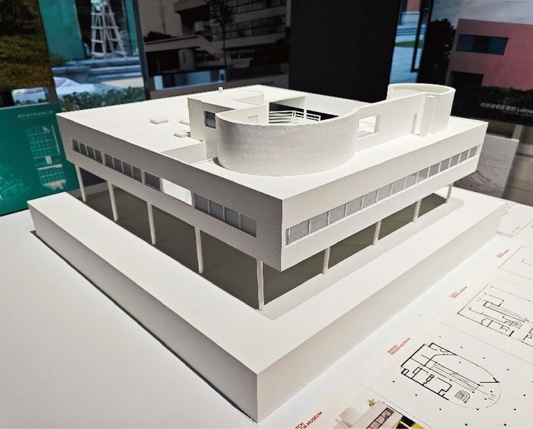 White model of a modernist villa with horizontal window bands and a curved roof