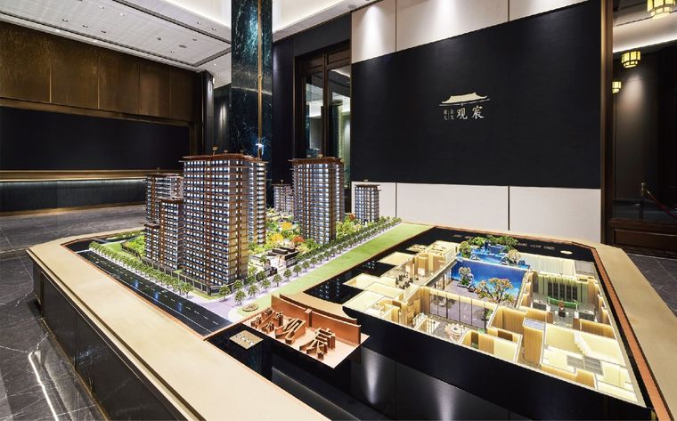 Model of a residential project with its show-apartment sections on a dark base