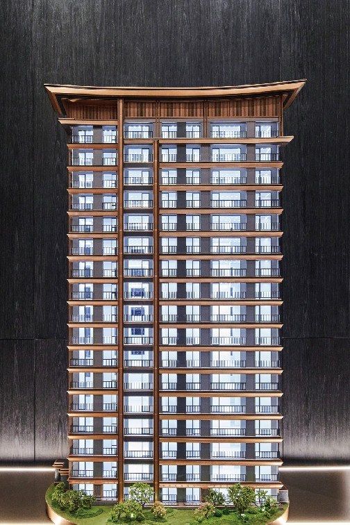 Model of a residential tower with a lit horizontal facade against black