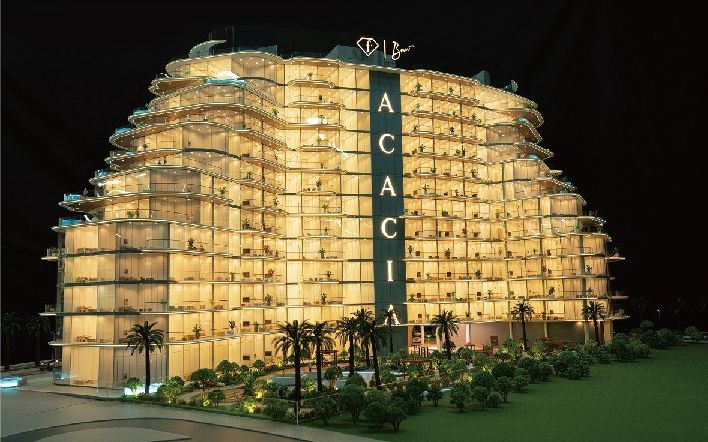 Model of a residential building with stepped balconies, golden light and palms around it