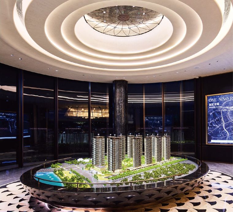 Model of a residential project on a circular base beneath an ornate dome
