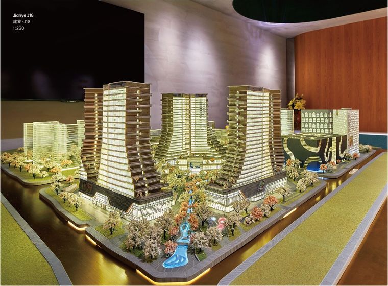 Model of a residential and retail complex with golden light and a stream