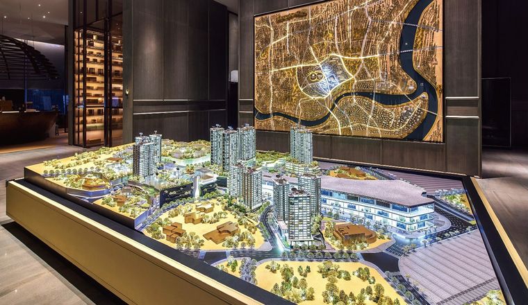 Model of a residential and retail project before a lit map