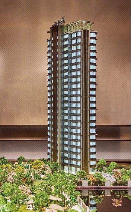 Model of a slender residential tower on a lit display base