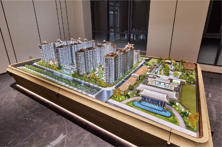 Model of a residential complex suspended above a lit base