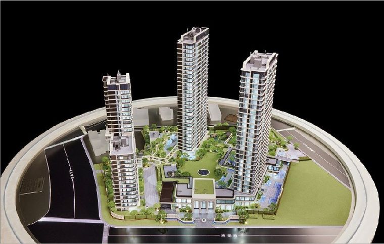 Model of three residential towers on a white oval base