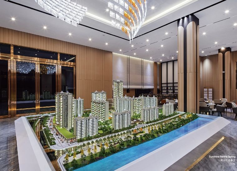 Model of a residential complex in a lobby with a crystal chandelier and a water feature