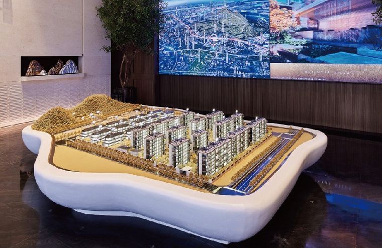 Model of a residential district on a curved white base before project photographs