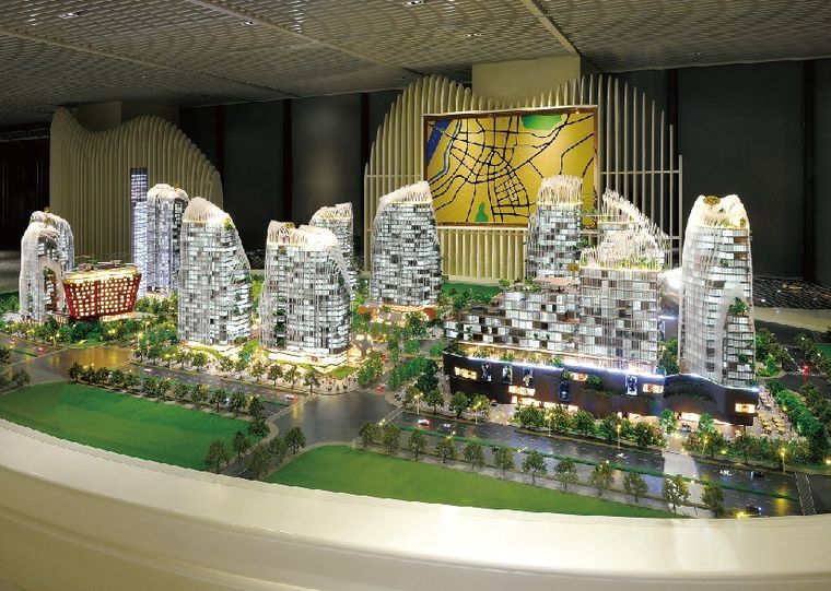 Model of a residential and retail complex with sculpted roofs and a central plaza