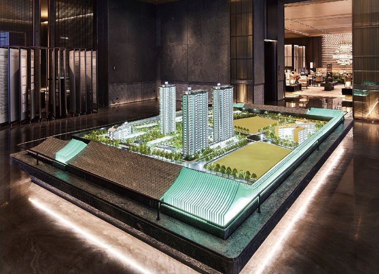 Model of a residential complex on a green base in a stone-lined lobby