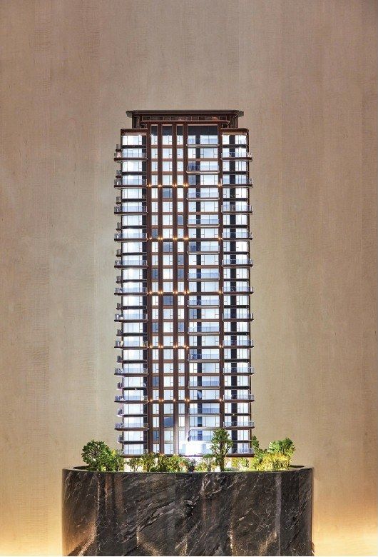 Model of a residential tower with repeating balconies on a stone base
