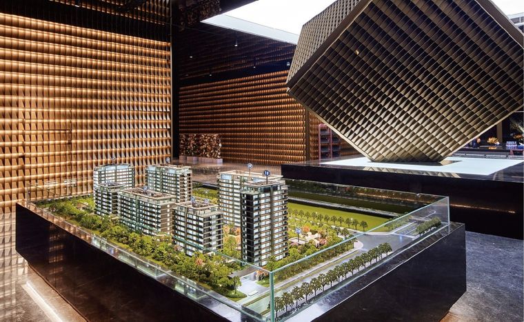 Model of a residential complex inside a glass vitrine under a copper ceiling