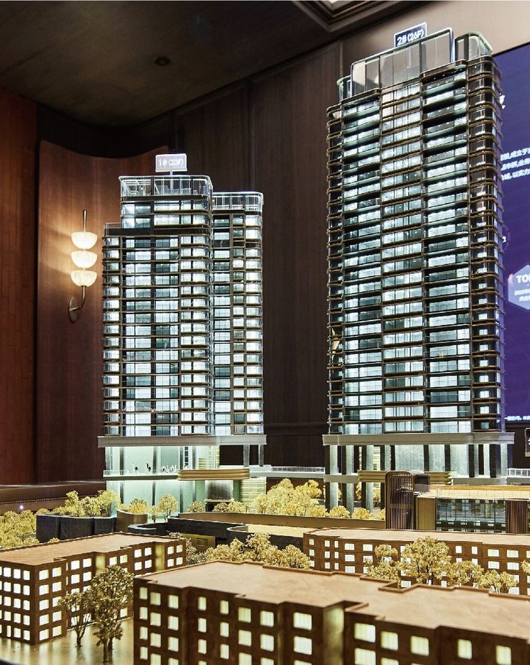 Model of two residential towers above a retail podium in a sales gallery