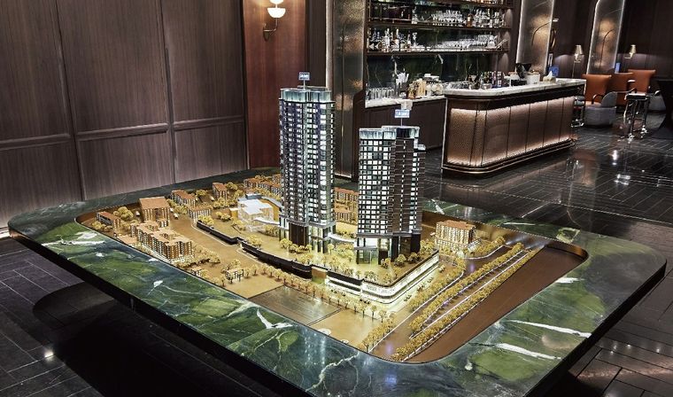 Model of a residential project on a marble table in a bar lobby