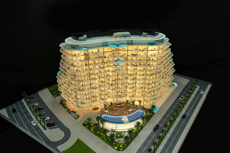 The same residential project lit at night on a base that includes roads and parking