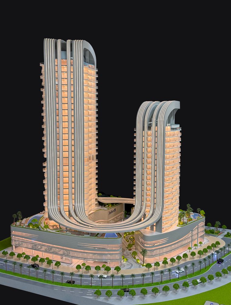 Two curved residential towers on a single base with interior lighting