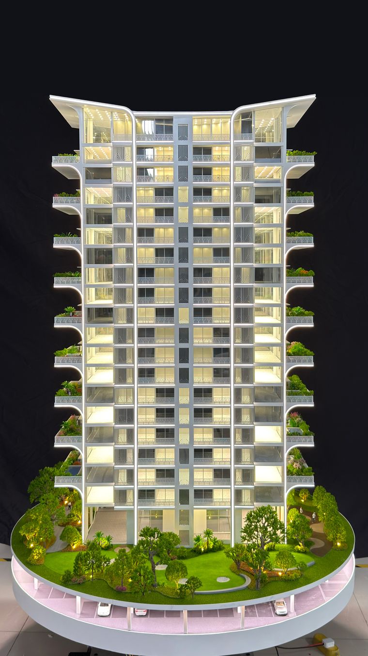Slim residential tower on a circular base ringed by trees