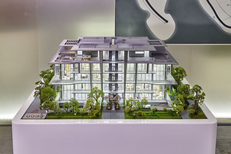 Contemporary residential building model on a white base with planting around it