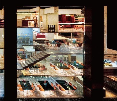 Cutaway model of a restaurant complex over four floors under warm light