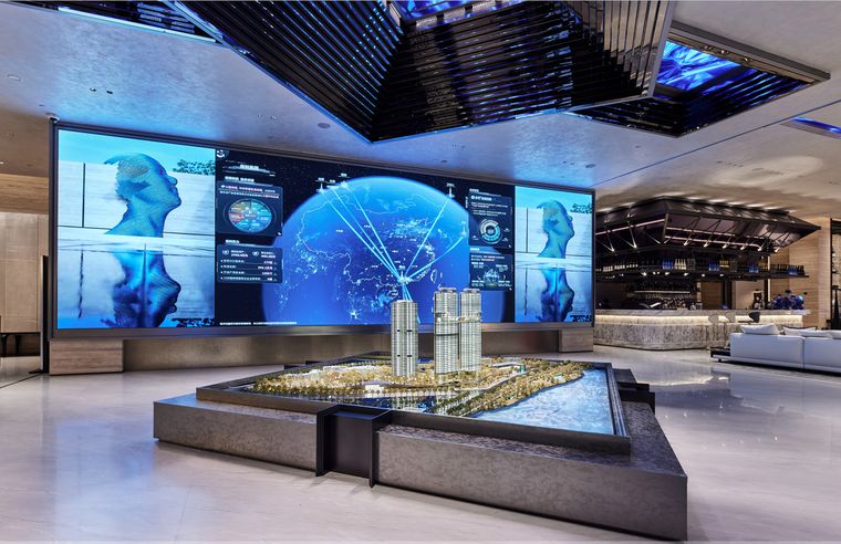 Immersive hall with wrap-around screens and a central model